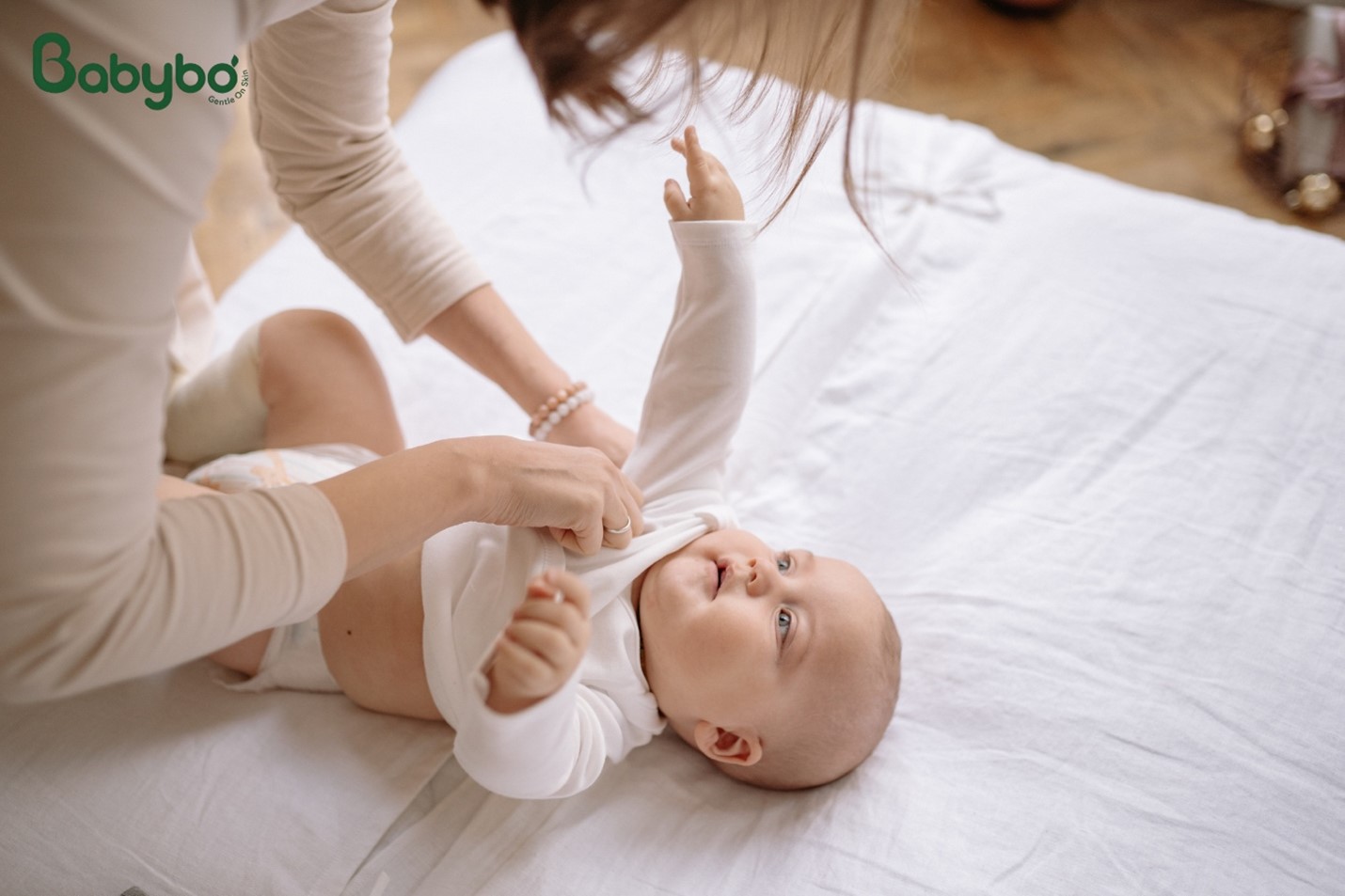 Mặc quần áo thoáng mát, thấm hút tốt giúp bé dễ chịu hơn khi sốt và hạn chế bí da trong mùa nóng.